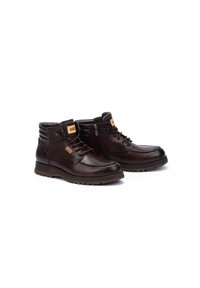 Bottines en cuir marron avec lacets et fermeture éclair sur le côté, dotées d'un col rembourré et d'une semelle en caoutchouc texturée pour une meilleure adhérence. Étiquette de marque sur la languette.