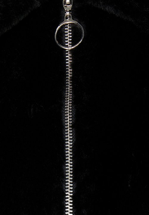 Čierna umelá kožušina s centrálnym strieborným zipsom a kruhovým ťahákom, ktorá zdôrazňuje hladkú textúru a čistý dizajn.