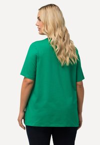 Zelené tričko s krátkým rukávem v měkké bavlněné směsi s volným střihem, s klasickým výstřihem a rovním lemem. Minimalistický design, jednobarevné.