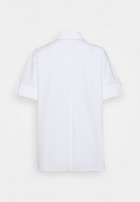 Camicia bianca a maniche corte con dettagli ai polsini ripiegati, cucitura dritta sul retro e colletto classico, esposta su uno sfondo neutro.