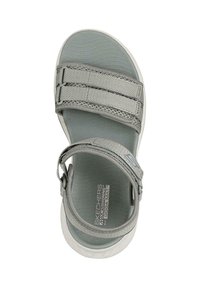 Sandal gris con correas ajustables, que presenta una plantilla texturizada y una suela acolchada. Diseño liviano con un bucle para facilitar su uso.