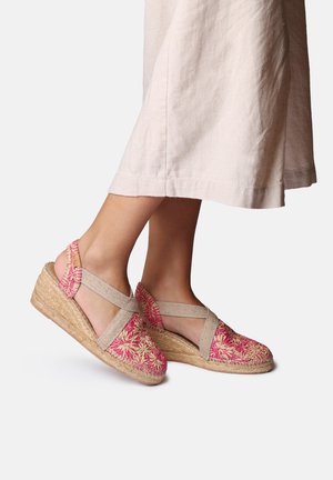 Roze geborduurde espadrille sleehakken met een geweven jutezool, voorzien van tan elastische bandjes die over de voet kruisen en een gestructureerd stoffen bovenwerk.
