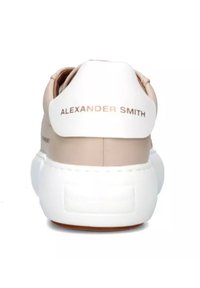 Sneaker in pelle beige con suola bianca. Presenta una finitura liscia, forma arrotondata e il marchio "ALEXANDER SMITH" in oro sulla linguetta del tallone.