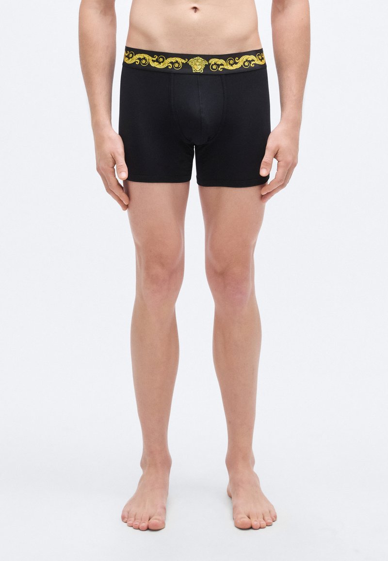 Μαύρα αντρικά μποξέρ με χρυσή μέση διακοσμημένη  με μπαρόκ σχέδιο. Κατασκευασμένα από απαλό, ελαστικό ύφασμα που προσφέρει άνετη εφαρμογή.