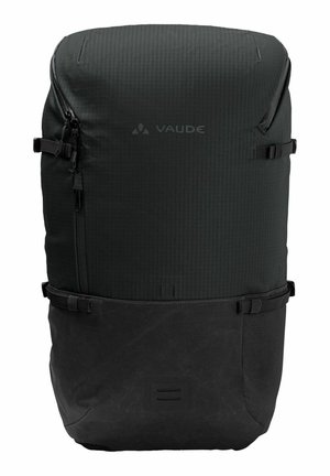 Sac à dos Vaude noir avec une surface texturée et un compartiment inférieur lisse, doté de zippers, de bretelles réglables et d'un design minimaliste.