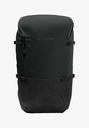 Sac à dos Vaude noir avec une surface texturée et un compartiment inférieur lisse, doté de zippers, de bretelles réglables et d'un design minimaliste.