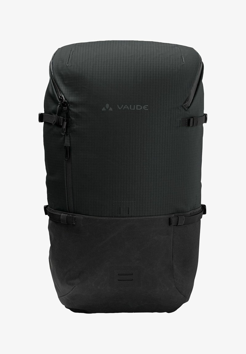 Mochila Vaude negra con una superficie texturizada y un compartimento inferior liso, que cuenta con cremalleras, correas ajustables y un diseño minimalista.