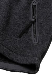 Tissu en polaire gris foncé présentant une texture lisse, doté d'une poche zippée sur le côté et d'un ourlet côtelé pour une fonctionnalité accrue.