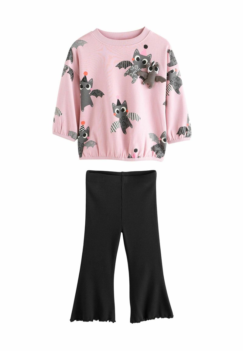 Ljusrosa sweatshirt med lekfulla fladdermustryck, kombinerad med svarta utsvängda leggings. Plagget är designat för barn.