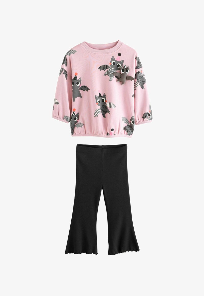 Rosa Langarmshirt mit Cartoon-Fledermäusen und einer kleinen Plüschfledermaus auf der Brust, kombiniert mit schwarzen ausgestellten Hosen für Kinder.