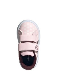 Sneaker rosa con pois bianchi, due strappi in velcro e suola in gomma. Presenta un interno scuro e un accento con logo sullo strap.