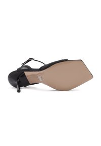 Zwarte hoge hak schoen met een pointed toe en een transparante zool, voorzien van een slanke enkelband en een gladde afwerking.