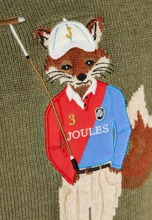 Strikket ræv iført en rød og blå polo med teksten "Joules", beige bukser, hvid kasket med bogstavet "J," holder en golfkølle foran en grøn baggrund.