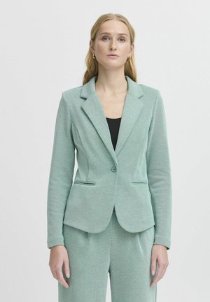 Svetle zelený blazer z texturované látky s přiléhavým střihem, zapínání na jeden knoflík a dvěma předními kapsami.