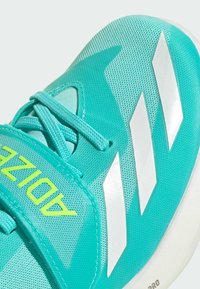 Scarpa sportiva turchese con tomaia in rete, strisce bianche e una cinghia in Velcro che presenta la scritta "ADIZERO" in giallo neon. Suola in gomma liscia.
