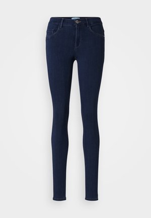 Skinny jeans in dark blue denim. Features a mid-rise waist, belt loops, five pockets, and a button-fly opening with a smooth texture.
