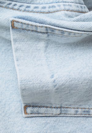Light blue denim fabric with a soft texture, featuring visible stitching in a contrasting brown color and folded edges.