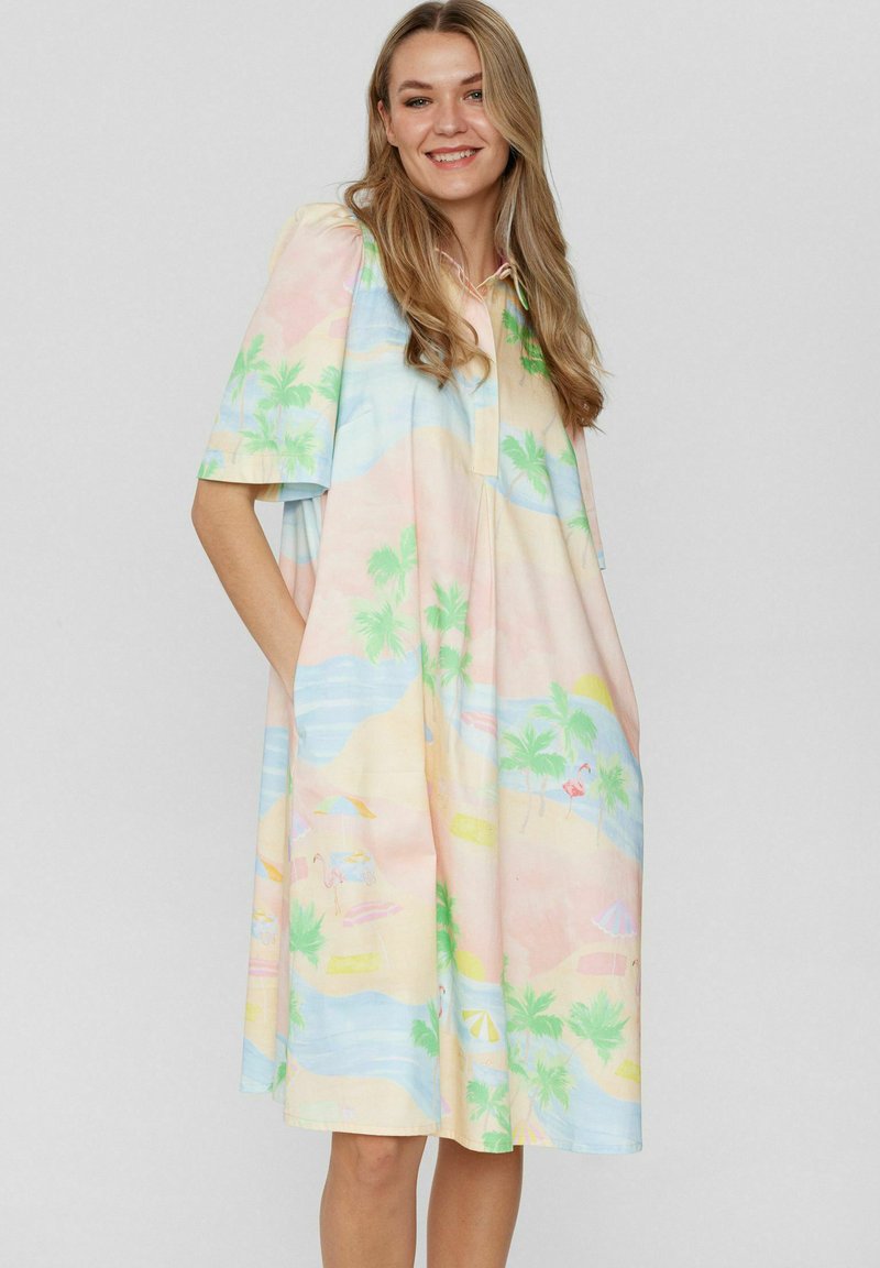 Rochie cu mânecă scurtă în culori pastelate, cu modele de palmieri și plajă. Confecționată dintr-un material ușor, cu un design cu guler și buzunare.