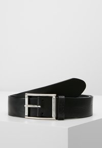 Cinturón de cuero negro con una hebilla rectangular plateada. Presenta una textura suave y un diseño sencillo. Acentuado con un logo en el pasador.