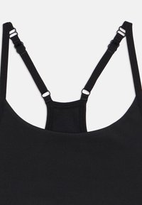 Μαύρο τοπ με λεπτές διπλές ρυθμιζόμενες τιράντες στους ώμους και μικρό πίσω πάνελ που ενώνει τις τιράντες.