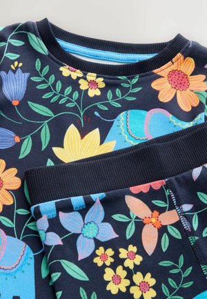 Tumesinine puuvillane komplekt, mis sisaldab elavaid lille- ja elevandimustreid sinises, kollases ja roosas, ning millel on ribatrepiga kaeluse ja varrukate äär.