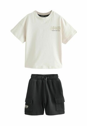 Weißes T-Shirt mit kurzen Ärmeln und dem Schriftzug "BAKER NINETEEN EIGHTY EIGHT", kombiniert mit schwarzen Cargo-Shorts mit seitlichen Taschen und Kordelzug.
