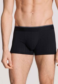 Zwarte katoenen boxershorts met een ribbelstructuur, voorzien van een elastische tailleband met een contrasterende lichtblauwe accent.