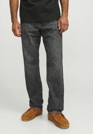 Jeans in denim grigio scuro con un fitted dritto, caratterizzati da un leggero effetto lavato e abbinati a scarpe slip-on in suede marrone chiaro.