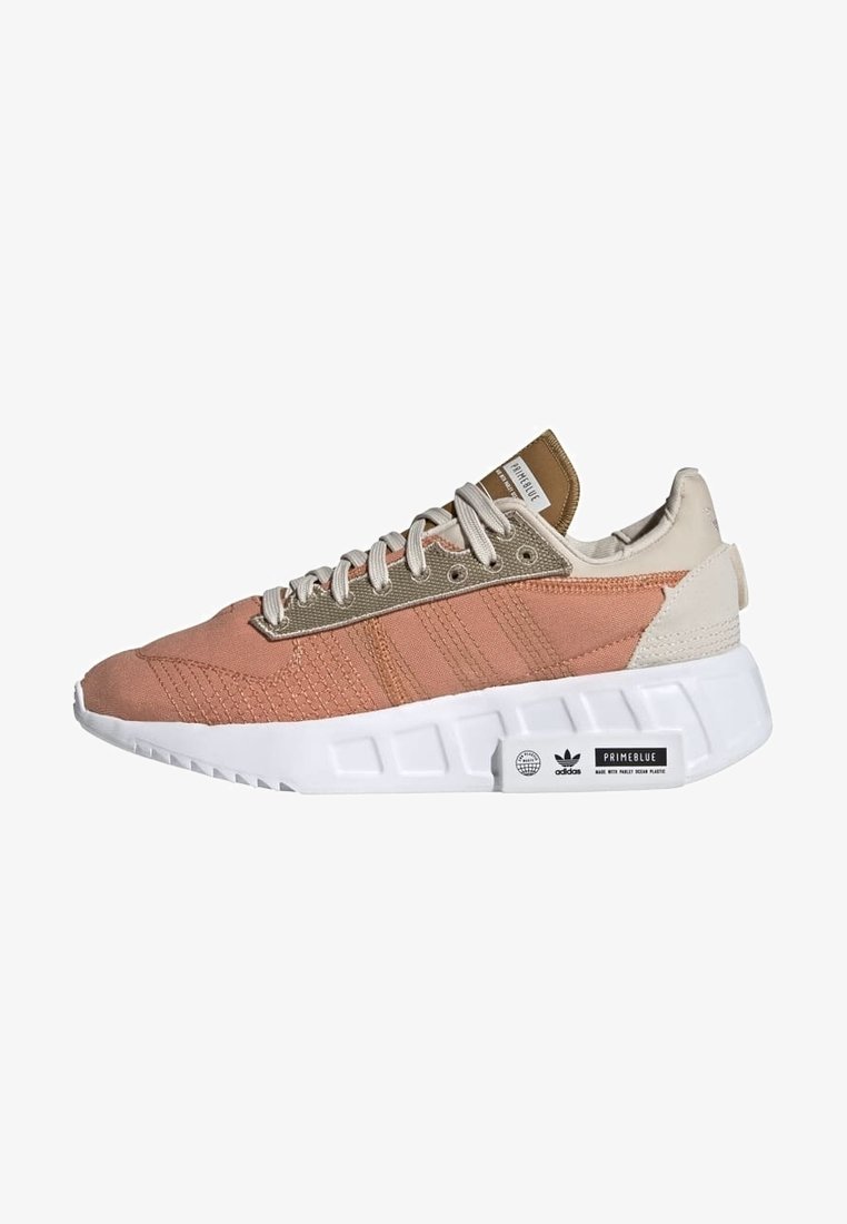 Pink and beige sneaker featuring a mixed fabric upper, textured details, three stripes, and a thick white sole with branding accents.