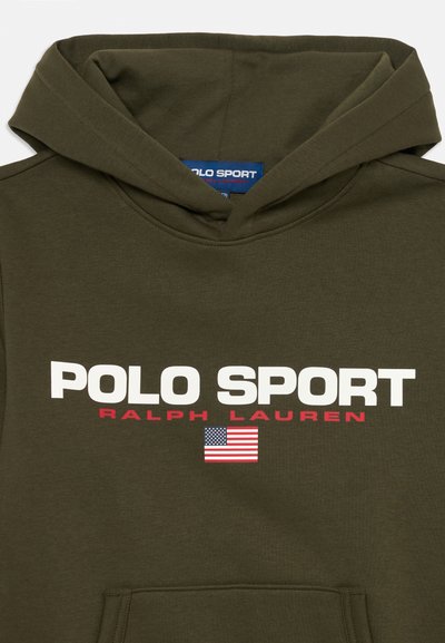 Maslina zelena dukserica s kapuljačom, na kojoj je ispisano "POLO SPORT" u bijeloj boji i "RALPH LAUREN" u crvenoj. Dodat je mali grafički prikaz američke zastave.
