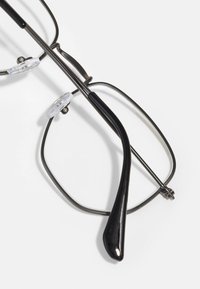 Ochelari de metal negri cu o formă rectangulară, cu suporturi pentru nas transparente și tâmplă curbă, cu accente negre netede.