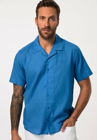 Camisa de botones de manga corta azul, hecha de una tela ligera, con un cuello relajado, una textura sutil y un pequeño logotipo bordado.