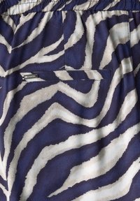 Zebra print fabric in navy and cream, featuring a small pocket on the back and an elastic waistband for comfort and fit.
