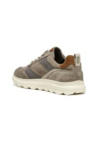 Sneaker in suede grigio con design testurizzato, dotate di strisce grigio scuro e un accento marrone sul tallone, completate da una suola bianca.