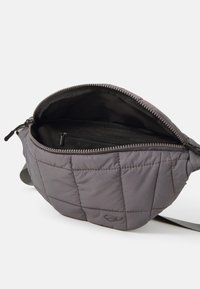 Borsa in tessuto grigio trapuntato con forma curva, chiusura con zip e tasca interna. Texture liscia, design minimalista con un logo sottile.