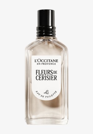 Przezroczysta szklana butelka z czarną zakrętką. Posiada białą etykietę z czarnym tekstem. Zawiera jasny płyn, reprezentujący zapach kwiatu wiśni.