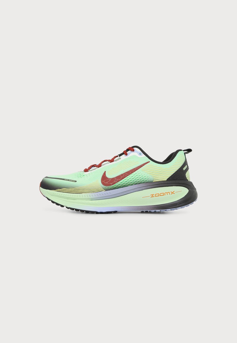 Ανοιχτό πράσινο παπούτσι για τρέξιμο Nike ZoomX με κόκκινο swoosh, κόκκινα κορδόνια, μαύρη φτέρνα και παχύ μαξιλαροειδές πέλμα σε λευκό φόντο.