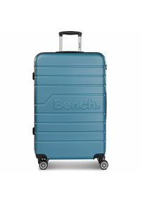 Hartsch suitcase in Türkis mit geriffeltem Design, das ein markantes Logo, einen ausziehbaren Griff und vier Rollen für Mobilität aufweist.
