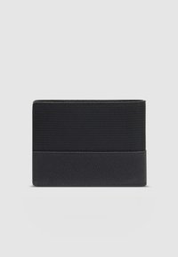 Cartera negra con sección superior texturizada y base de cuero suave. Forma rectangular compacta con líneas limpias, sin herrajes visibles.