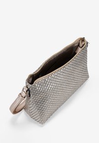 Bolso de mano tejido en plata con un acabado brillante, cierre superior con cremallera y correa desmontable. El interior está forrado con un suave material beige.