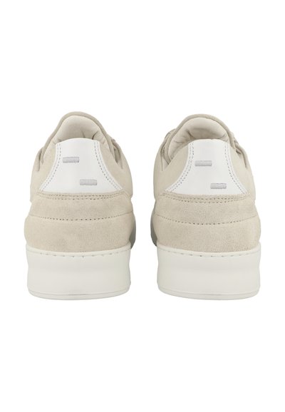 Beige suede sneakers with white accents, featuring a smooth back, low profile, and minimalistic design. Subtle stitching detail visible.