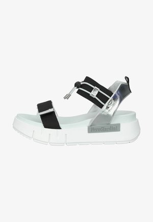 Black and silver platform sandals with elastic straps, metallic accents, and a white chunky sole featuring a textured design.