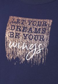 Granatowa bawełniana koszulka z metalicznym złotem różowym wzorem z napisem "NIECH TWOJE MARZENIA BĘDĄ TWOIMI Skrzydłami" w różnych stylach czcionek.