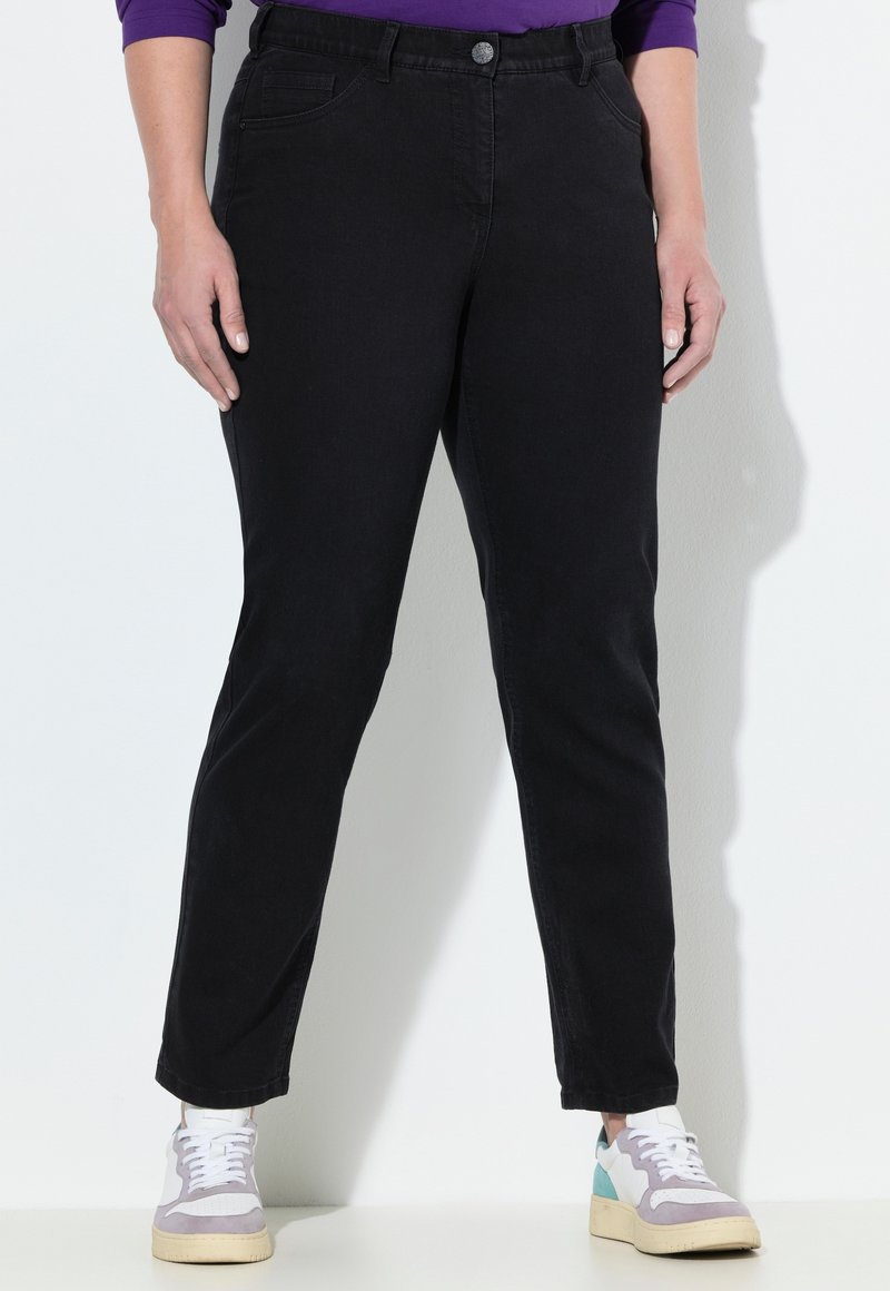 Mustat farkut slim-fit-leikkauksella, etutaskuilla ja napilla suljettuna. Yhdistetty monivärisiin lenkkareihin. Yhdistelee sileää kangasrakennetta.