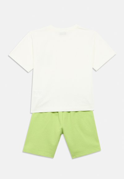 Άσπρο κοντομάνικο μπλουζάκι με στρογγυλή λαιμόκοψη συνδυασμένο με πράσινα σορτς. Και τα δύο κατασκευασμένα από απαλό βαμβάκι με λεία υφή.