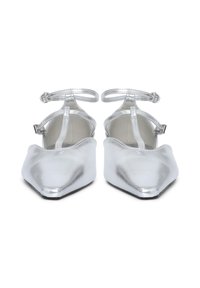 Ballet flats argento metallici a punta con cinturini alla caviglia e dettagli a T, viste frontalmente su uno sfondo bianco.
