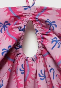 Tessuto rosa con un motivo floreale che presenta accenti blu. Raccoglie attorno a un'apertura ovale, mostrando una finitura texture e liscia.
