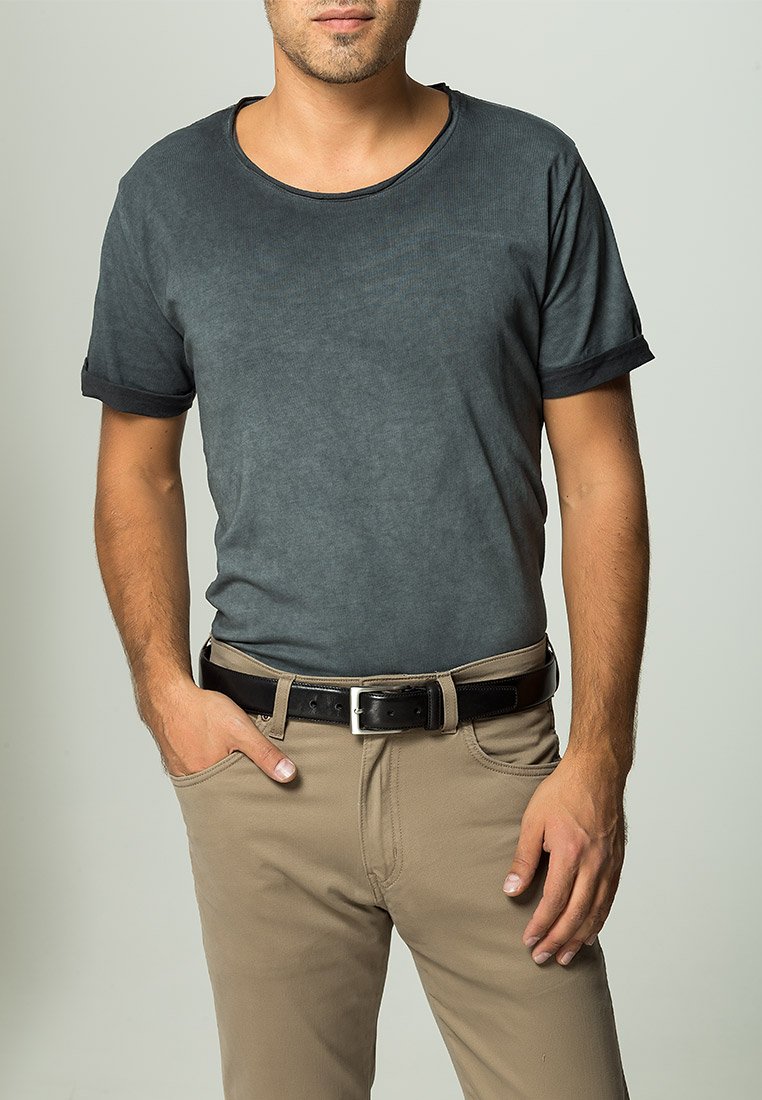 Grå kortermet T-skjorte med rund hals og rullede ermer, kombinert med beige bukser og et svart belt, som skaper et avslappet utseende.