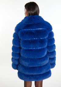 Blauer Kunstpelzmantel mit einem geschichteten, gestreiften Design, hohem Kragen und langen Ärmeln, weicher Textur und einer Länge bis zur Mitte des Oberschenkels.