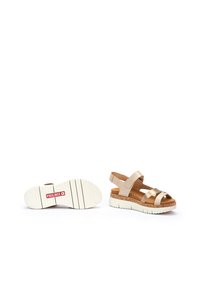 Sandali beige con più cinturini e una soletta imbottita. Suola in gomma bianca con motivo testurizzato e dettagli del logo. Accenti in sughero.